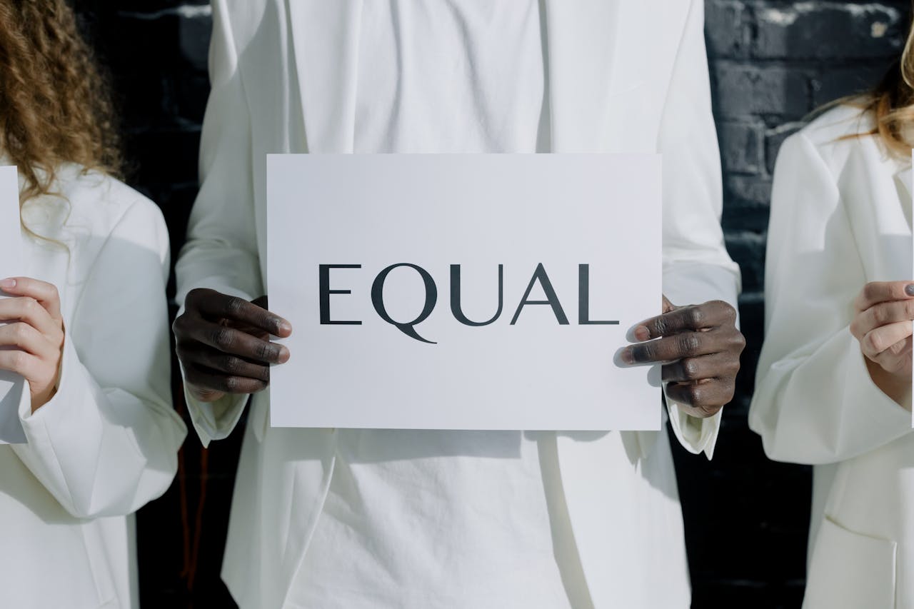 Diverse group holding an 'Equal' sign, symbolizing equality and unity.